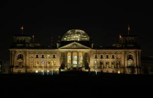 Das nachts beleuchtete Reichstagsgebäude mit gläserner Kuppel in Berlin